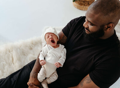 newborn-yawning-on-dads-lap