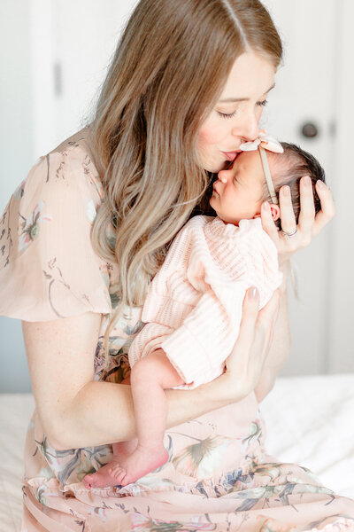 Mom kisses newborn baby girl during her lifestyle Newborn Session taken by Brooke Leigh Photography, Southeast Michigan Newborn Photographer