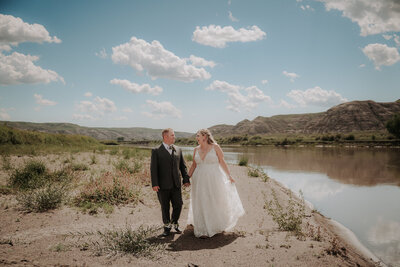 A bride and groom walk up the aisle after getting married, being showered in flower petals.