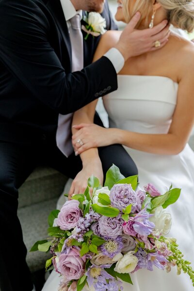 Bride holding vibrant bouquet with lavender, lilac, and pink florals