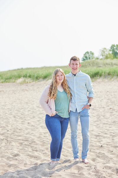 A heartwarming image of Meg Williamson's children posing on the scenic long shore. The picture captures a moment of joy and connection, set against the backdrop of the beautiful coastal landscape.