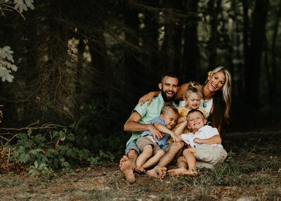 A Pittsburgh family is posing for a photo in the woods.