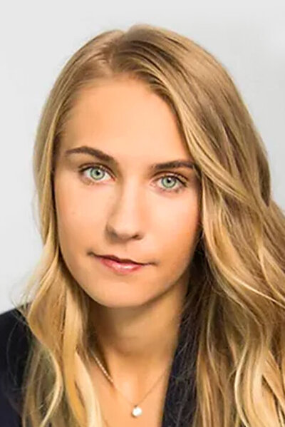 Headshot of entertainment attorney Alicia Newman. She is a young woman with long blonde hair, light green eyes and is wearing a black blazer.