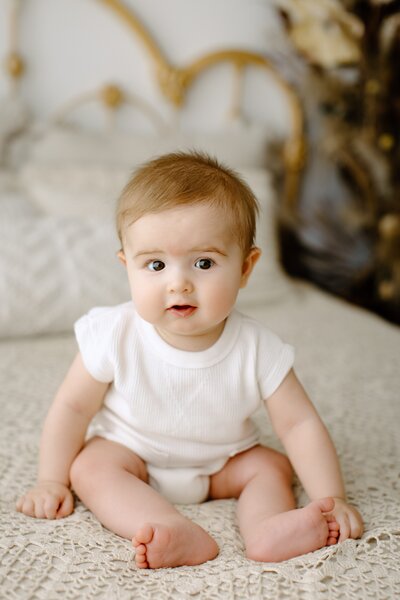 Family photography child sitting on bed in white with boho background in Tampa Bay, Florida Nadine B Photography