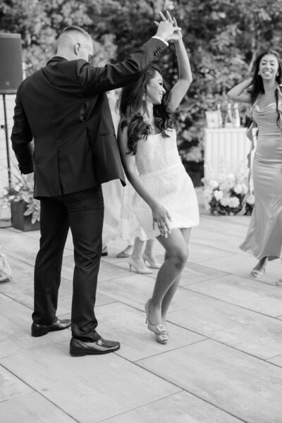 Guests enjoying a lively dance at a wedding reception at Winbrooke in Brookshires, Massachusetts. The bride and her guest share a joyful moment on the dance floor, surrounded by friends and family. Felisha, a New England-based destination wedding photographer, captures timeless and candid moments at weddings in Massachusetts, New England, and worldwide locations.
