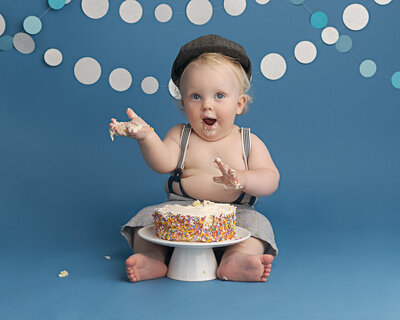 baby boy in brown romper with star garland for first birthday session in hillsboro