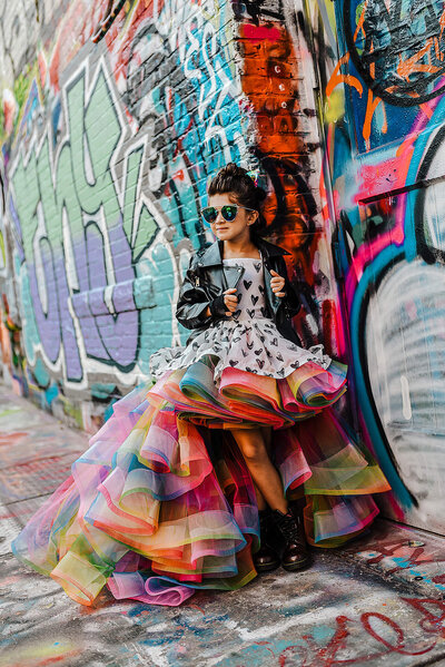 Girl in Rainbow dress in graffiti Alley Baltimore near MICA with sunglasses and boots