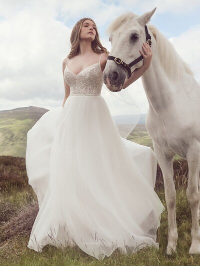 Floral appliques create a raceback effect against the illusion back of this gown.