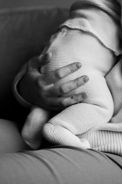 Een vrouw houdt een baby in haar armen, met een liefdevolle en zorgzame uitstraling.