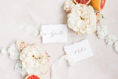Handmade paper place cards with  black calligraphy and white silk ribbon