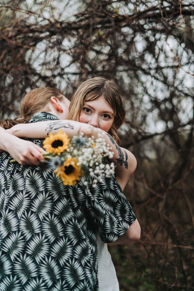 A sweet embrace between two people with sunflowers and baby's breath bouquet creating a romantic mood.