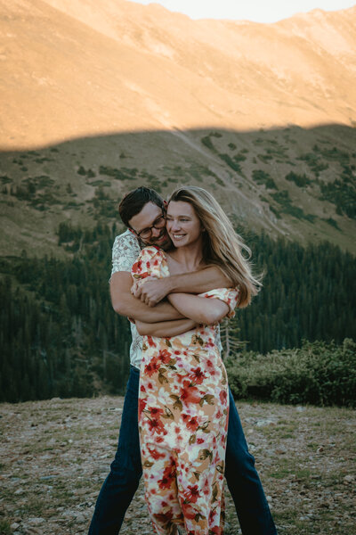 A couple has the engagement session in the summer in the Colorado mountains