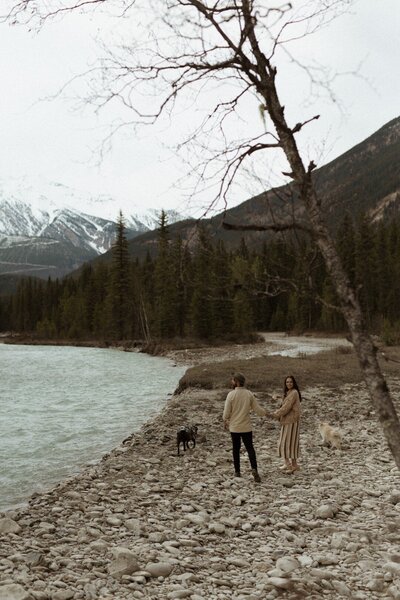 Couple and dog walking along creek in Canada