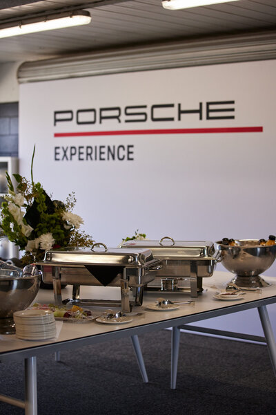 Vase of green and white flowers sitting amongst serving silverware, at a brand experience event.