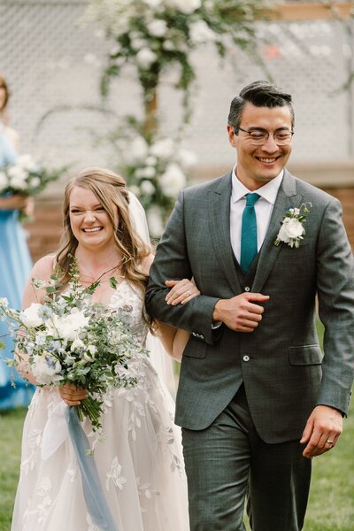 Bride and Groom walk down the aisle with a dusty blue, sage, and white bouquet at the St. Julien Hotel in Boulder, Colorado.