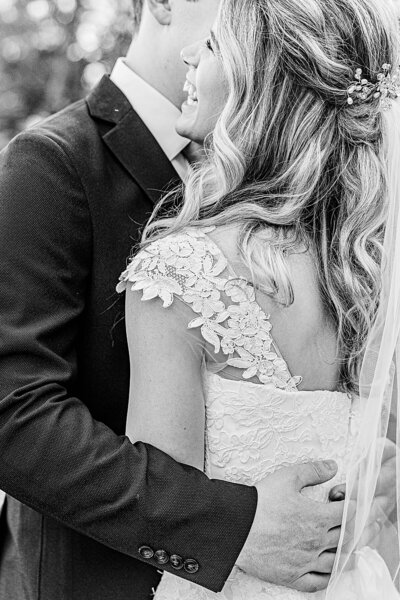 Bride laughing over grooms shoulder