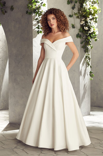 Mikaella Lace Wedding Dress. Mikaella Lace gown with sleeveless bodice and plunging neckline. Removable Mokuba Ribbon with beading at waist. Full circle skirt with pockets and scallop at hem.