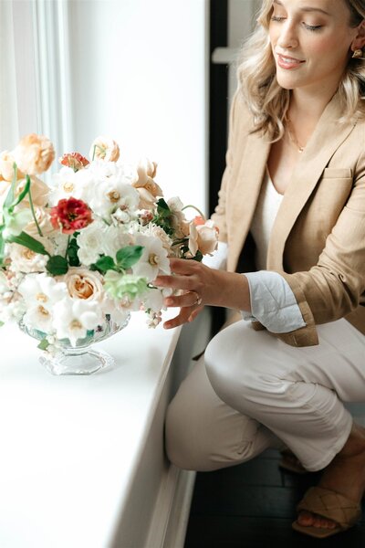 wedding planner Catherine Boizelle adjusts a floral arrangement