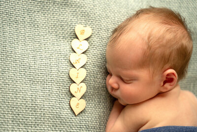 newborn-baby-posed-on-beanbag-with-beautiful-headband