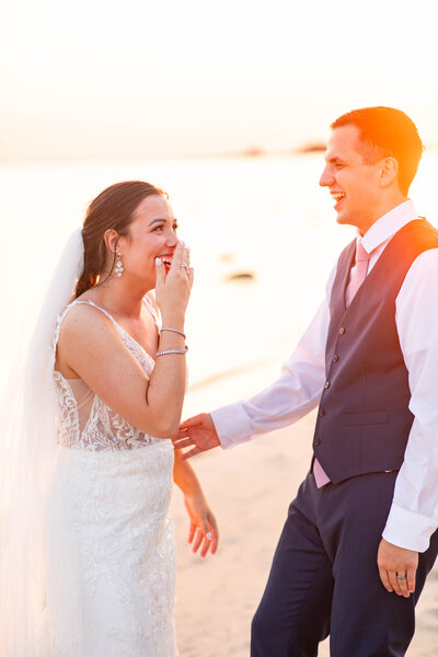 Bride and Groom bend down to kiss their pups on their wedding day