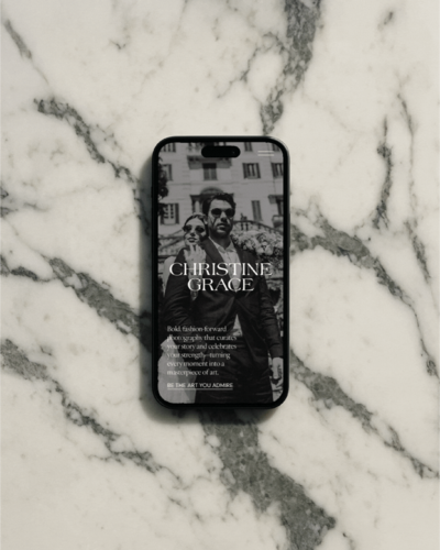 Smartphone on a marble background displaying Christine Grace Photography's mobile website design.