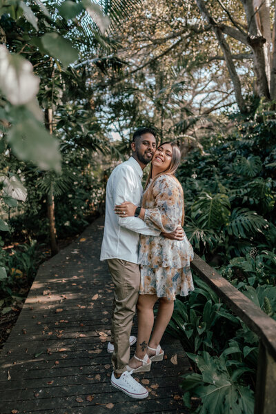 Duraan & Maalyka walking along a board walk in a forest during an engagement photoshoot with Zanthe Vorsatz in Auckland