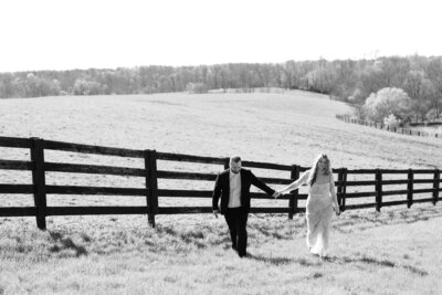 Couple dressed in elegant outfits standing next to a ranch, for a romantic session.