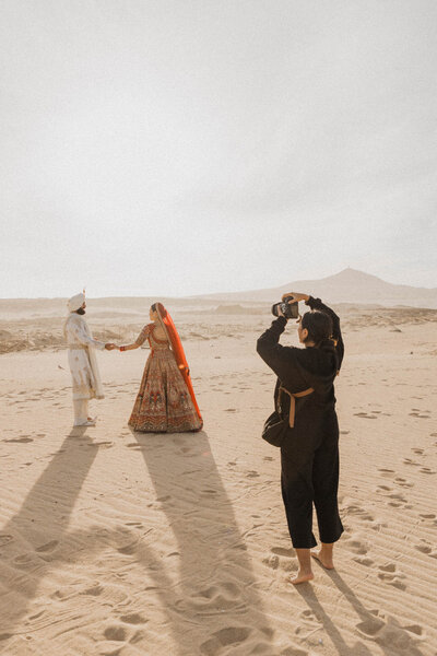 Emily Rohman photograher taking photo of couple in sand desert