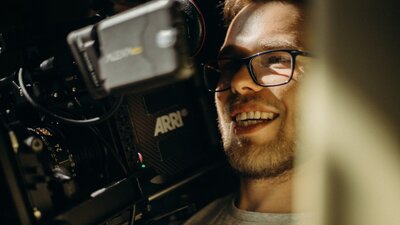 smiling filmmaker with a camera