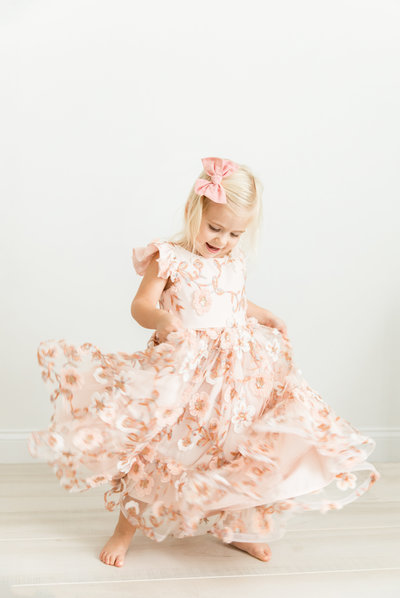 little girl twirling in pink dress