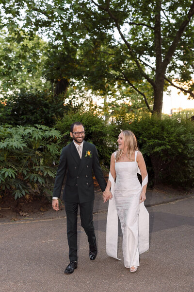 Wedding photographer captures couple taking a stroll hand in hand at their french chateau wedding.