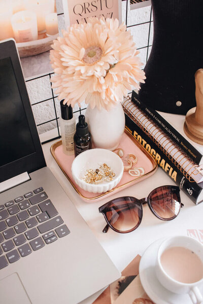 Computer, sunglasses, and stack of books