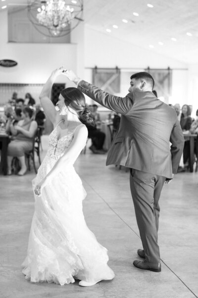 Groom twirling bride during wedding first dance