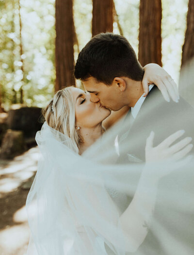 bride & groom kissing in the forest