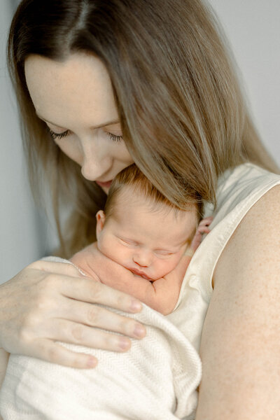 mom holding newborn in Miami Studio by Sandra Vallejo