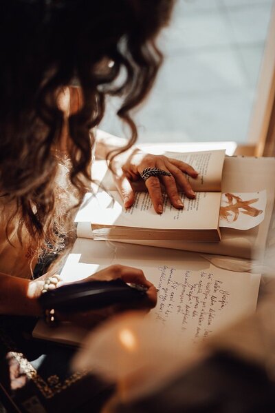 Woman writing with book open