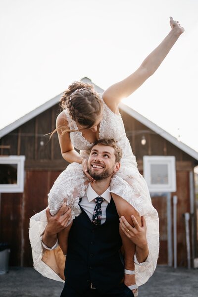 A bride on her grooms shoulders on their wedding day