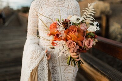 bride and groom holding hands while their bridal party is standing around them