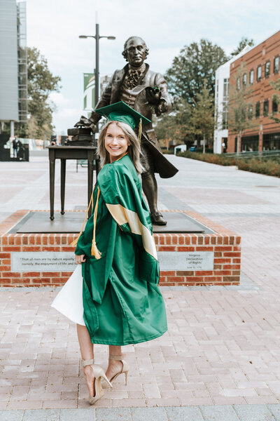 College senior in cap and gown on campus at George Mason University