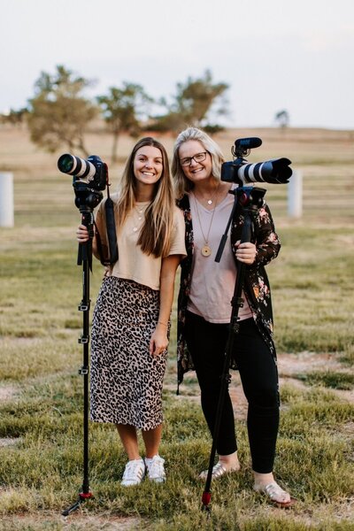 Kaylyn and Dana Pulley holding their cameras and smiling at the camera