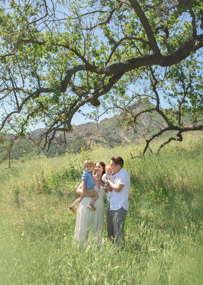 Family of 4 at Malibu creek state park in the greenery photographed by Los Angeles family photographer