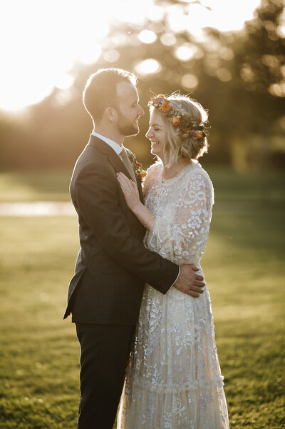 flower bridal headband on bride and laughing with groom at sunset