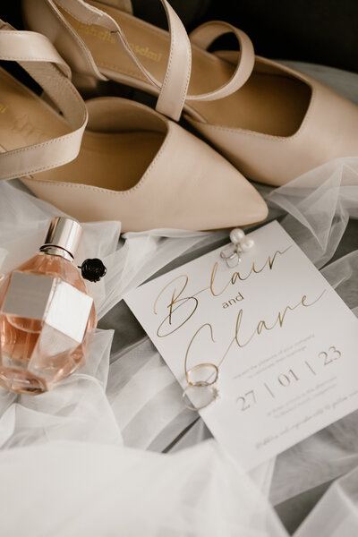 A wedding flatlay photo of the stationary and brides shoes