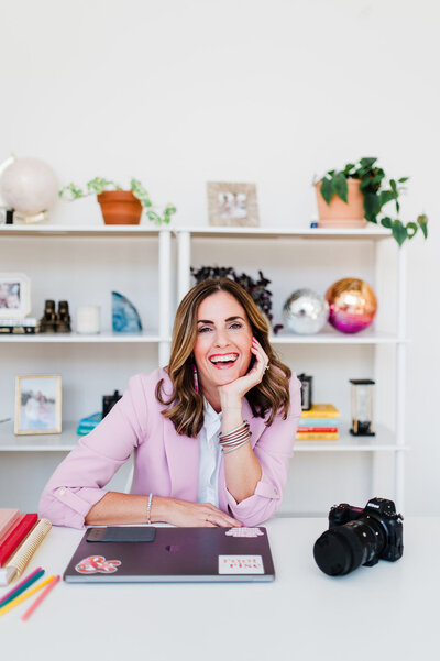 headshot of a woman wearing pink teaching photographers about marketing