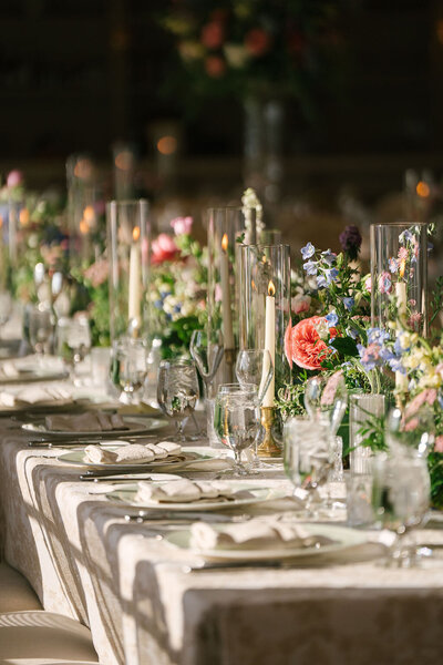 luscious summer ceremony on a tented prairie, blush and pink blooms and organic whimsical greenery for altar arch
