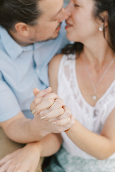 couple holding hands and almost kissing in the background