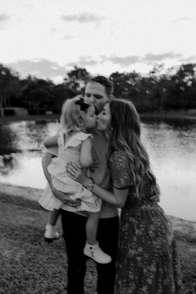 Parents Kissing Daughter