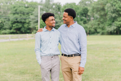 Father and adult son smiling at each other