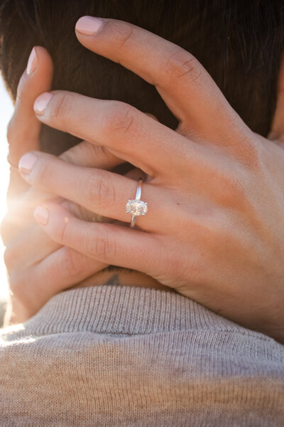 lesbian couple embracing with engagement ring