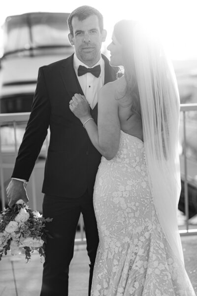 black and white photo of a bride and groom during golden hour on the dock at the marina del rey hotel